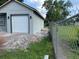 Side view of a gray house with a one-car garage and a chain-link fence along the property line at 2451 W 18Th St, Sanford, FL 32771