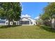 Expansive backyard with lush green lawn, mature trees, and a charming screened-in porch, ideal for outdoor living at 408 Lexingdale Dr, Orlando, FL 32828