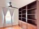 Bedroom features wood floors, a ceiling fan, window with curtains, and a built-in bookshelf at 7808 The Esplanade Ct, Orlando, FL 32836