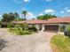 Beautiful home with a circular driveway and lush landscaping with palm trees and lovely green grass at 7808 The Esplanade Ct, Orlando, FL 32836