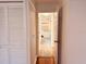 Hallway featuring white closet doors and a view into a light and airy kitchen space with white cabinets at 7808 The Esplanade Ct, Orlando, FL 32836