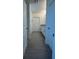 Hallway view of bathroom featuring white cabinetry, granite countertops, and modern gray tile flooring at 11015 Bostwick Aly, Winter Garden, FL 34787