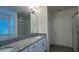 Bathroom showcasing a dual sink vanity with granite countertops, modern fixtures, and a glass-enclosed shower at 11015 Bostwick Aly, Winter Garden, FL 34787