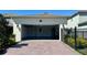 Spacious garage with ample parking and a brick paver driveway, enhancing curb appeal at 11015 Bostwick Aly, Winter Garden, FL 34787