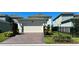 Home with a two-car garage, driveway, and manicured landscaping featuring a well maintained lawn at 11015 Bostwick Aly, Winter Garden, FL 34787