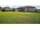 Sprawling backyard featuring lush green grass, mature trees, and a screened patio perfect for outdoor living at 11041 Se 169Th Pl, Summerfield, FL 34491