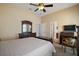 Bright bedroom with a ceiling fan, dresser with mirror, and door to the en suite bathroom at 11041 Se 169Th Pl, Summerfield, FL 34491