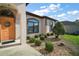 Charming home exterior with a decorative front door, arched window, manicured shrubs, and stone accents at 11041 Se 169Th Pl, Summerfield, FL 34491
