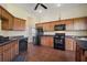 Functional kitchen featuring wooden cabinets, black appliances, and ample counter space at 11041 Se 169Th Pl, Summerfield, FL 34491