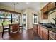 Practical kitchen featuring wood cabinets, a mobile island, and a large window overlooking the backyard at 11041 Se 169Th Pl, Summerfield, FL 34491