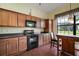 Bright kitchen featuring wood cabinets, black appliances, and plenty of counter space at 11041 Se 169Th Pl, Summerfield, FL 34491
