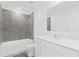 Well-lit bathroom with modern gray-tiled shower and vanity with white countertop at 1179 Tyler Loop, Winter Haven, FL 33884