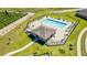 Aerial shot of a community pool area featuring a clubhouse, lounge chairs, and manicured landscaping at 1179 Tyler Loop, Winter Haven, FL 33884