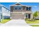 Two-story home showcasing a well-manicured lawn and a two-car garage, offering curb appeal at 1179 Tyler Loop, Winter Haven, FL 33884