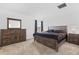 Carpeted main bedroom with dresser, nightstand, and full size bed at 1179 Tyler Loop, Winter Haven, FL 33884