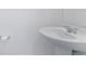 A pedestal sink in a powder room, showcasing simplicity and functionality with a toilet paper holder at 1179 Tyler Loop, Winter Haven, FL 33884