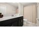 Neutral bathroom featuring a vanity with a black cabinet and a shower with curtain at 12180 Sonnet Ave, Orlando, FL 32832