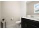 Powder room featuring a single sink vanity with a black cabinet, and a white toilet at 12180 Sonnet Ave, Orlando, FL 32832