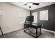 Office space featuring sleek black desk, carpet, and dark painted accent wall with artwork at 12180 Sonnet Ave, Orlando, FL 32832