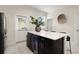 Kitchen island featuring a wine cooler, black cabinetry, and white countertop with seating at 12180 Sonnet Ave, Orlando, FL 32832
