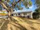 Quaint single-story home with a new metal roof, featuring a well-maintained front yard and mature trees at 1311 Bryn Mawr Ave, Lake Wales, FL 33853