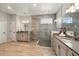 Modern bathroom features a spacious walk-in shower, double vanity, and wood-look flooring at 13202 Spring Grove Way, Winter Garden, FL 34787