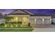 Home exterior featuring illuminated landscaping, garage, and holiday lighting at dusk at 13202 Spring Grove Way, Winter Garden, FL 34787