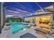 A beautifully lit screened-in pool with a spa and lounge chairs creates a relaxing nighttime ambiance at 13202 Spring Grove Way, Winter Garden, FL 34787