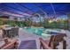 Elegant screened-in pool and spa area at dusk, with an outdoor dining set and cozy Adirondack chairs at 13202 Spring Grove Way, Winter Garden, FL 34787