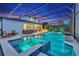 A glowing screened-in pool and spa area is illuminated at twilight, with adjacent outdoor living spaces at 13202 Spring Grove Way, Winter Garden, FL 34787