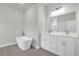 Bathroom featuring double sink vanity, gray tile flooring, and a white soaking tub at 13673 Sw 43 Cir, Ocala, FL 34473