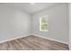 Empty room boasting wood-look floors and a bright window, offering a simple, clean aesthetic at 13673 Sw 43 Cir, Ocala, FL 34473