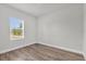 An empty bedroom with wood-look floors and a bright window, perfect for customization at 13673 Sw 43 Cir, Ocala, FL 34473