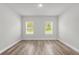 This bedroom features wood-look flooring and two windows that provide natural light to the room at 13673 Sw 43 Cir, Ocala, FL 34473