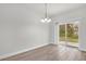 Bright dining area with wood-look floors, a modern chandelier, and sliding glass doors to the backyard at 13673 Sw 43 Cir, Ocala, FL 34473