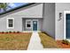 Close-up of a modern home's entrance featuring a blue door, white trim, and manicured landscaping at 13673 Sw 43 Cir, Ocala, FL 34473