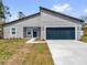 Charming single-story home featuring a modern gray exterior, blue door, and attached two-car garage at 13673 Sw 43 Cir, Ocala, FL 34473