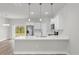 A modern kitchen features stainless steel appliances, white cabinetry and island with quartz countertop at 13673 Sw 43 Cir, Ocala, FL 34473
