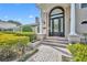 Close up of the home's beautiful arched doorway, trimmed with columns, and surrounding well maintained landscaping at 1370 Alberta Dr, Winter Park, FL 32789