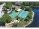 Aerial view showcases basketball and tennis courts near a pond, perfect for recreation and relaxation at 14021 King Sago Ct, Orlando, FL 32828