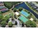Overhead photo displays a basketball court, tennis court, beach volleyball, and playground adjacent to a pond at 14021 King Sago Ct, Orlando, FL 32828