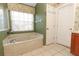 This bathroom features a soaking tub and a linen closet, offering relaxation and storage at 14021 King Sago Ct, Orlando, FL 32828