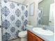 Well-maintained bathroom featuring a vanity, toilet, and shower with a decorative curtain at 14021 King Sago Ct, Orlando, FL 32828