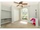 Bedroom featuring built-in desk area, closet and large window at 14021 King Sago Ct, Orlando, FL 32828