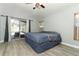 Cozy bedroom featuring a queen bed, wood-look tile flooring, sliding glass doors to pool at 14021 King Sago Ct, Orlando, FL 32828