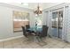 Dining area featuring a modern glass table, stylish chairs, a chandelier, and sliding glass doors to the patio at 14021 King Sago Ct, Orlando, FL 32828