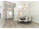 Open dining room with modern lighting, neutral decor, and wood-look flooring at 14021 King Sago Ct, Orlando, FL 32828