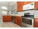 Well-lit kitchen featuring stainless steel appliances, wood cabinets, and ample counter space, perfect for cooking at 14021 King Sago Ct, Orlando, FL 32828