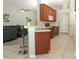 Open concept kitchen with stainless steel appliances, wood cabinets, and breakfast bar, with adjacent living area at 14021 King Sago Ct, Orlando, FL 32828