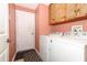 Practical laundry room featuring a washer, dryer, and wooden cabinets for ample storage at 14021 King Sago Ct, Orlando, FL 32828